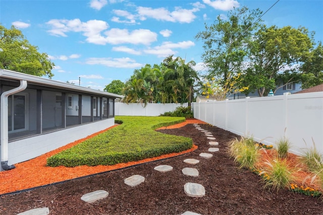 view of yard with a sunroom and a fenced backyard
