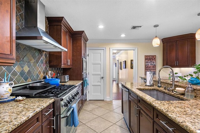 kitchen with tasteful backsplash, a sink, light tile patterned floors, wall chimney exhaust hood, and appliances with stainless steel finishes