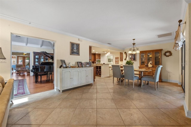 dining room with visible vents, an inviting chandelier, light tile patterned floors, and crown molding