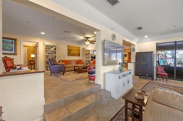 living room with a ceiling fan, a textured ceiling, built in features, visible vents, and recessed lighting