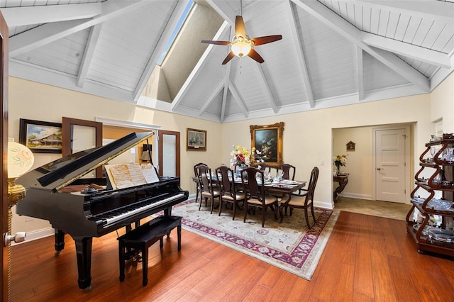 dining area with high vaulted ceiling, a ceiling fan, wood finished floors, baseboards, and beam ceiling