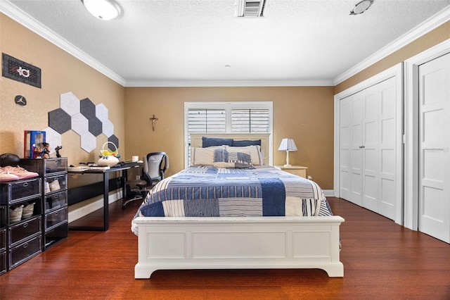 bedroom featuring ornamental molding, wood finished floors, and visible vents