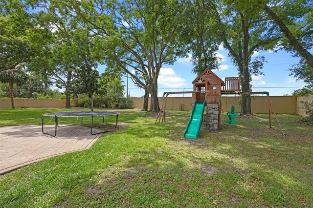 view of play area featuring a fenced backyard, a yard, and a trampoline