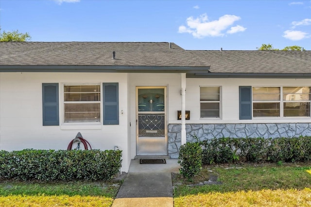 doorway to property with roof with shingles