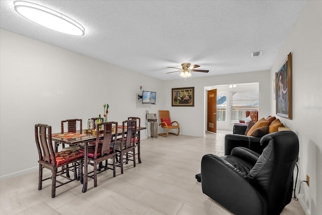 dining room with a textured ceiling, visible vents, and ceiling fan