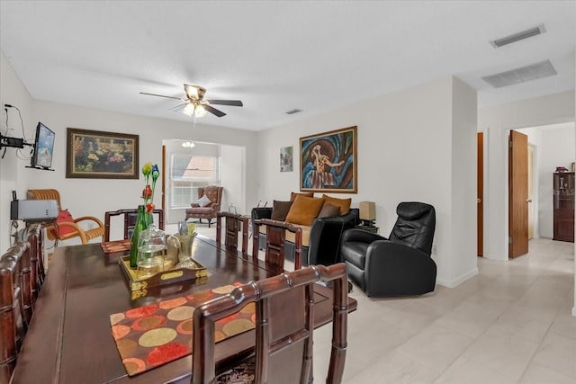 living room with baseboards, a ceiling fan, visible vents, and light tile patterned floors