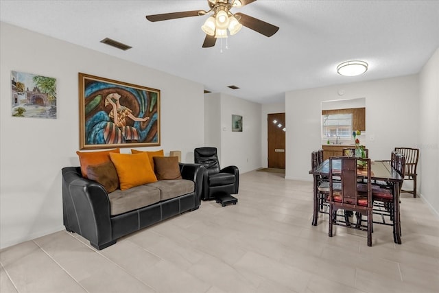 living area featuring visible vents and ceiling fan