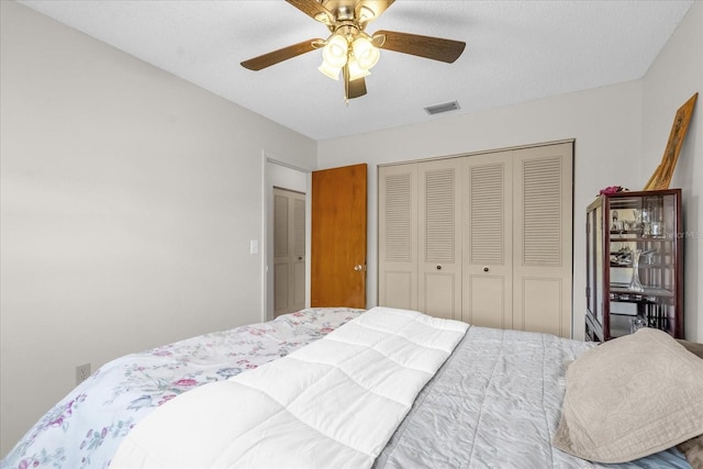 bedroom with a ceiling fan, visible vents, and a closet