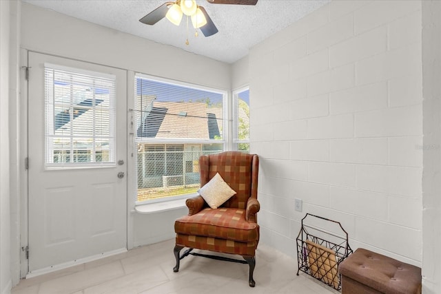 sitting room featuring ceiling fan and a textured ceiling