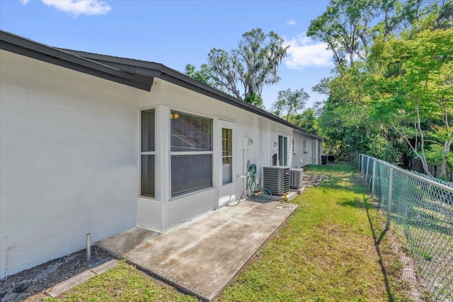 view of yard with central AC and fence