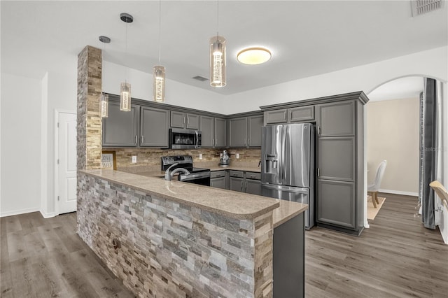 1114 Landale Ct, Orlando, FL 32828 - kitchen featuring appliances with stainless steel finishes, gray cabinetry, arched walkways, and a peninsula