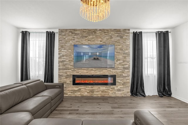 1114 Landale Ct, Orlando, FL 32828 - living room featuring a large fireplace, wood finished floors, plenty of natural light, and a chandelier