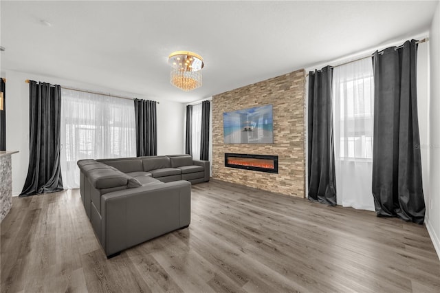 1114 Landale Ct, Orlando, FL 32828 - living room featuring a large fireplace, plenty of natural light, wood finished floors, and a chandelier