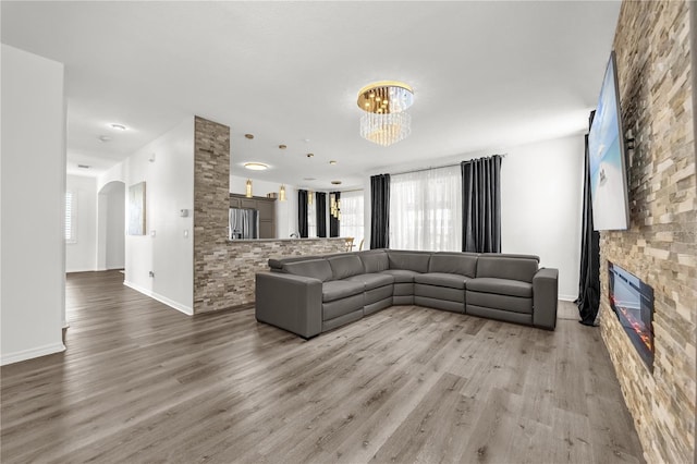 1114 Landale Ct, Orlando, FL 32828 - living room with a chandelier, a fireplace, wood finished floors, and arched walkways