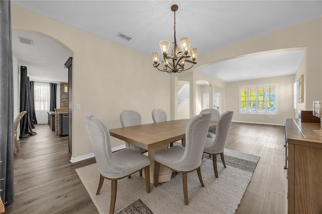 1114 Landale Ct, Orlando, FL 32828 - dining room with arched walkways, wood finished floors, and a chandelier