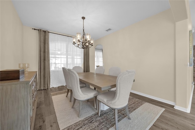 1114 Landale Ct, Orlando, FL 32828 - dining area with wood finished floors, a chandelier, and arched walkways