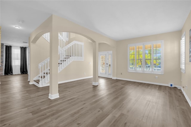 1114 Landale Ct, Orlando, FL 32828 - unfurnished living room with stairway, wood finished floors, and arched walkways