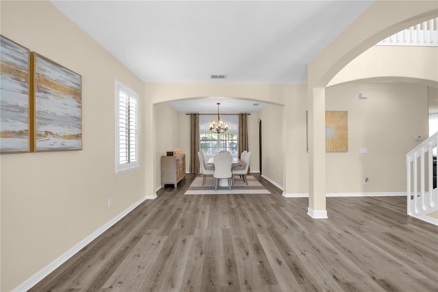 1114 Landale Ct, Orlando, FL 32828 - foyer entrance with wood finished floors, a chandelier, arched walkways, and stairway