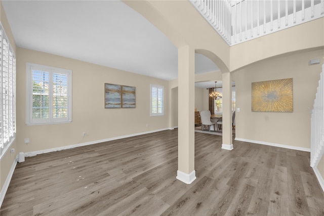 1114 Landale Ct, Orlando, FL 32828 - unfurnished living room with a chandelier, wood finished floors, and arched walkways