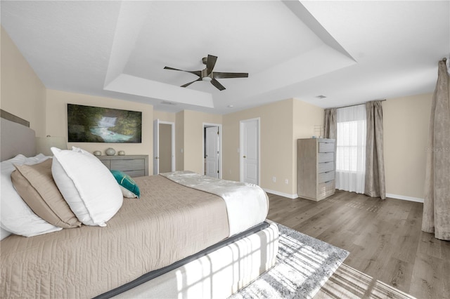 1114 Landale Ct, Orlando, FL 32828 - bedroom featuring a tray ceiling, wood finished floors, and a ceiling fan