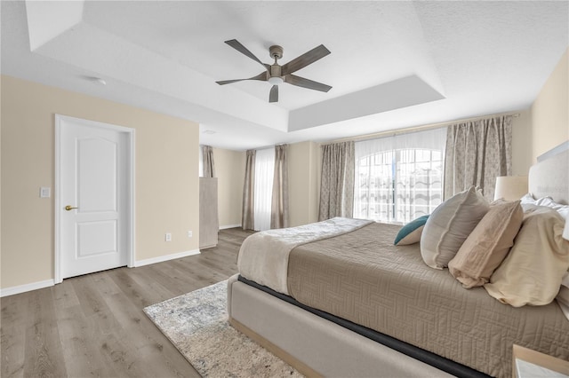 1114 Landale Ct, Orlando, FL 32828 - bedroom with a tray ceiling, wood finished floors, and a ceiling fan