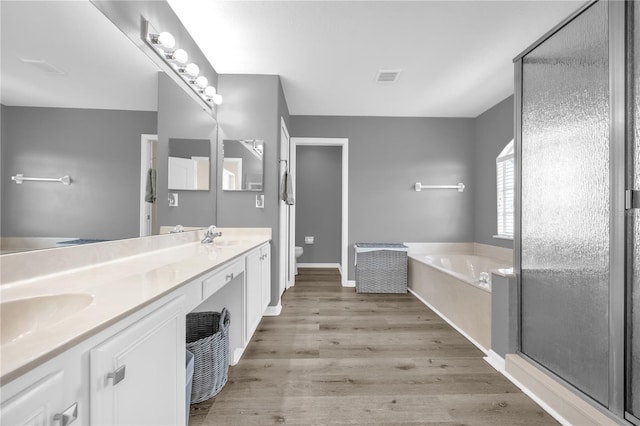 1114 Landale Ct, Orlando, FL 32828 - bathroom featuring double vanity, a bath, a stall shower, and wood finished floors