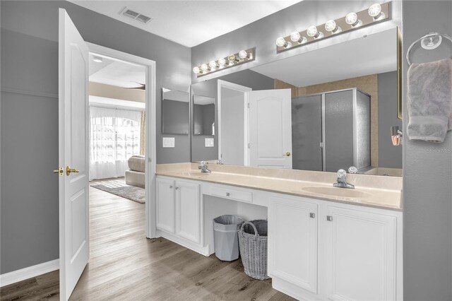 1114 Landale Ct, Orlando, FL 32828 - bathroom featuring double vanity, wood finished floors, a shower stall, and ensuite bathroom