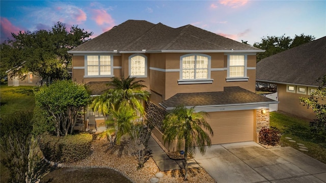 1114 Landale Ct, Orlando, FL 32828 - view of front of house with stucco siding, roof with shingles, driveway, an attached garage, and stone siding