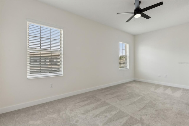 carpeted empty room featuring baseboards and ceiling fan