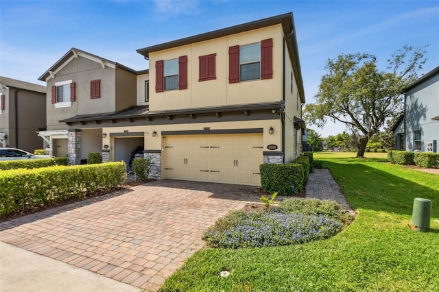 view of front facade with stucco siding, decorative driveway, a front yard, and a garage