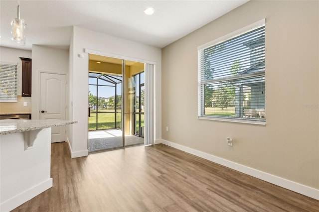 doorway with wood finished floors and baseboards