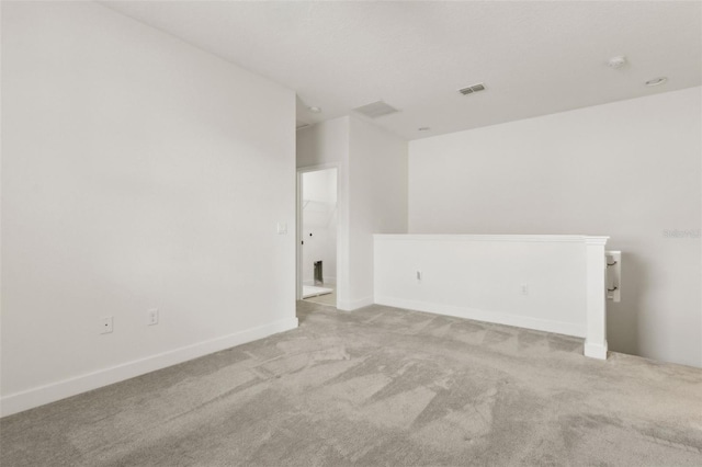 carpeted empty room featuring visible vents and baseboards