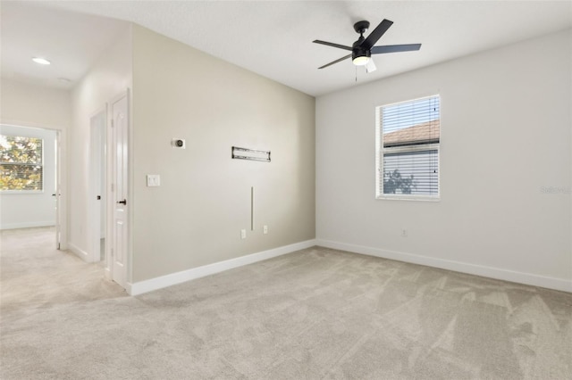 spare room with light colored carpet and baseboards