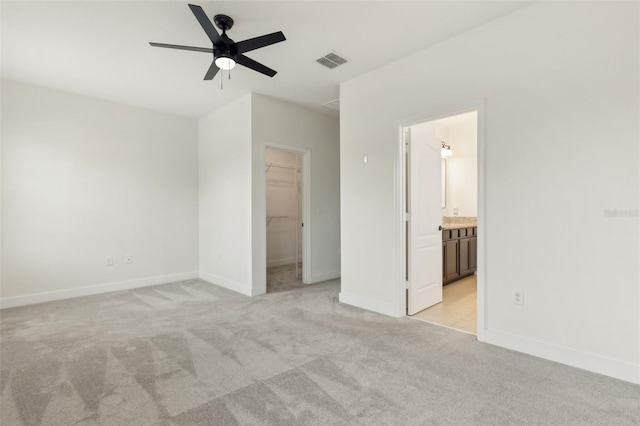 unfurnished bedroom featuring light carpet, baseboards, visible vents, and a spacious closet