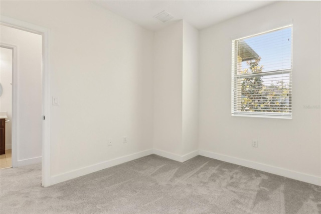 unfurnished room featuring light carpet, a healthy amount of sunlight, and baseboards