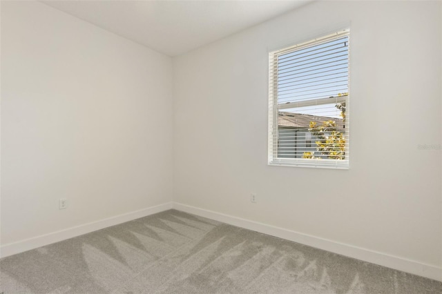 carpeted spare room featuring baseboards