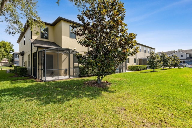 back of property featuring stucco siding, a lanai, a patio, and a lawn