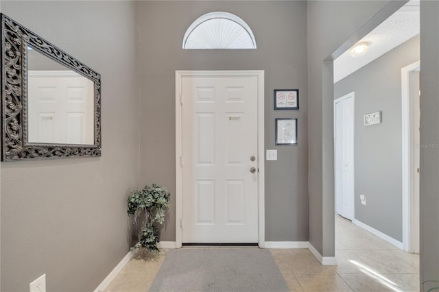 166 Laurel Ridge Pass, Davenport, FL 33897 - foyer entrance with light tile patterned floors, a high ceiling, and baseboards