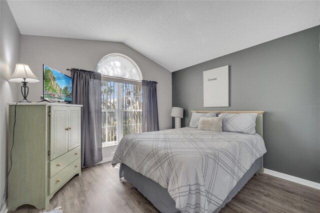 166 Laurel Ridge Pass, Davenport, FL 33897 - bedroom featuring a textured ceiling, wood finished floors, lofted ceiling, and baseboards