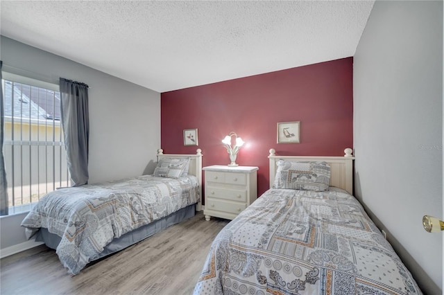 166 Laurel Ridge Pass, Davenport, FL 33897 - bedroom featuring a textured ceiling, an accent wall, and wood finished floors