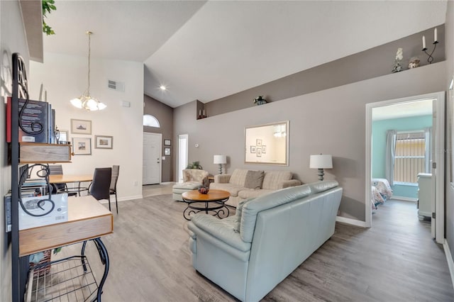 166 Laurel Ridge Pass, Davenport, FL 33897 - living area with a notable chandelier, high vaulted ceiling, visible vents, baseboards, and wood finished floors