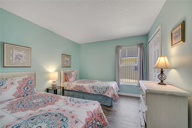 166 Laurel Ridge Pass, Davenport, FL 33897 - bedroom with a closet, a textured ceiling, wood finished floors, and baseboards