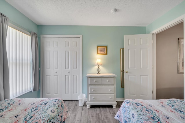 166 Laurel Ridge Pass, Davenport, FL 33897 - bedroom featuring a textured ceiling, wood finished floors, baseboards, and a closet
