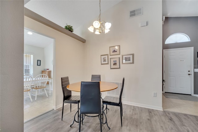 166 Laurel Ridge Pass, Davenport, FL 33897 - dining area featuring an inviting chandelier, a towering ceiling, visible vents, and wood finished floors