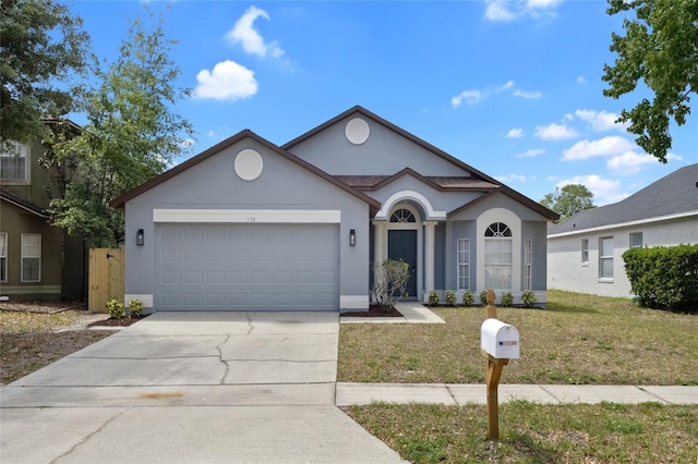ranch-style house with an attached garage, a front lawn, stucco siding, and concrete driveway