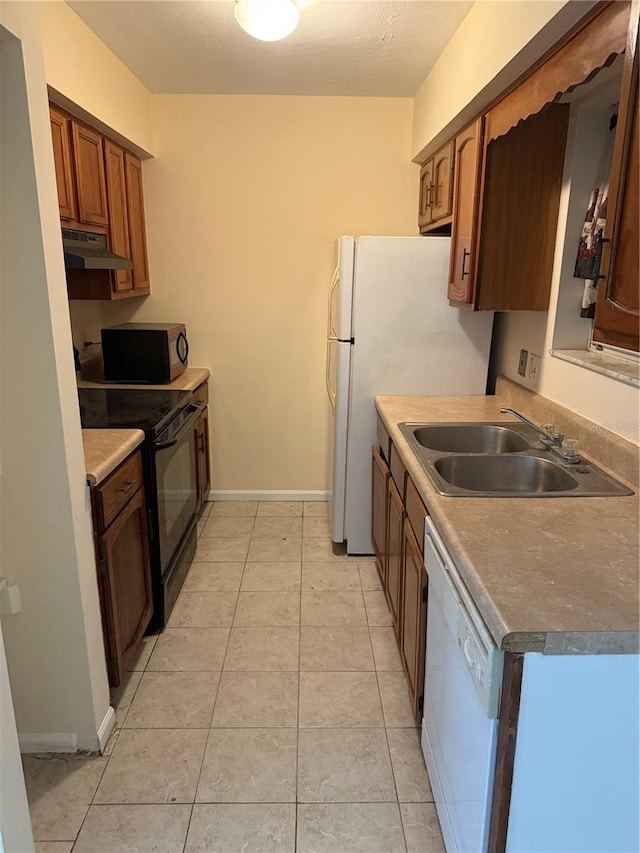 2102 69th Dr, Gainesville, FL 32608 - kitchen with a sink, brown cabinets, white appliances, baseboards, and under cabinet range hood