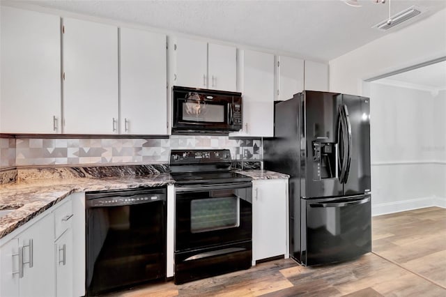 4216 Lake Underhill Rd Unit 6A2-8, Orlando, FL 32803 - kitchen featuring light wood finished floors, decorative backsplash, black appliances, visible vents, and white cabinetry