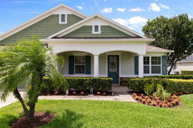 690 Cascading Creek Ln, Winter Garden, FL 34787 - bungalow-style house featuring a porch, a front lawn, central AC, and stucco siding
