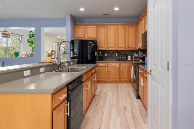 690 Cascading Creek Ln, Winter Garden, FL 34787 - kitchen with backsplash, visible vents, a sink, black appliances, and light wood-style flooring