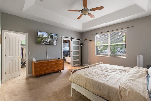 690 Cascading Creek Ln, Winter Garden, FL 34787 - bedroom with a tray ceiling, a barn door, baseboards, and carpet
